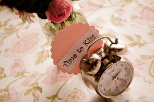 a clock with a funny tag is a cool decoration for a wedding table, pair it with blooms and greenery