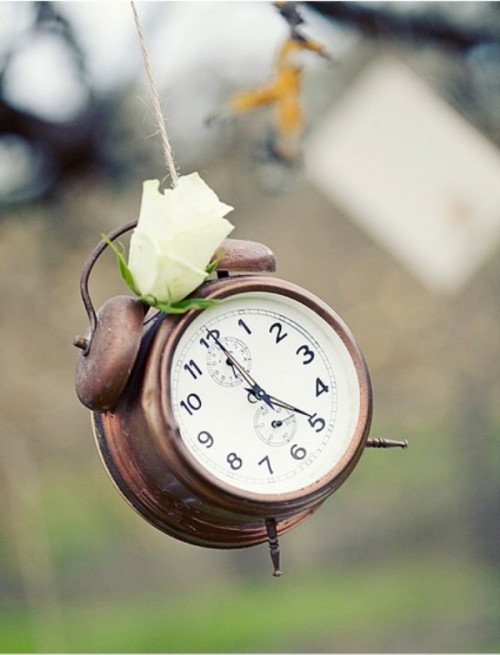 a vintage clock with a white bloom attached is a cool idea for a vintage wedding