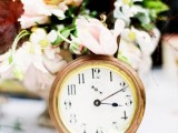 a pastel bloom wedding centerpiece with a clock is a pretty idea for a celestial, NYE or vintage wedding