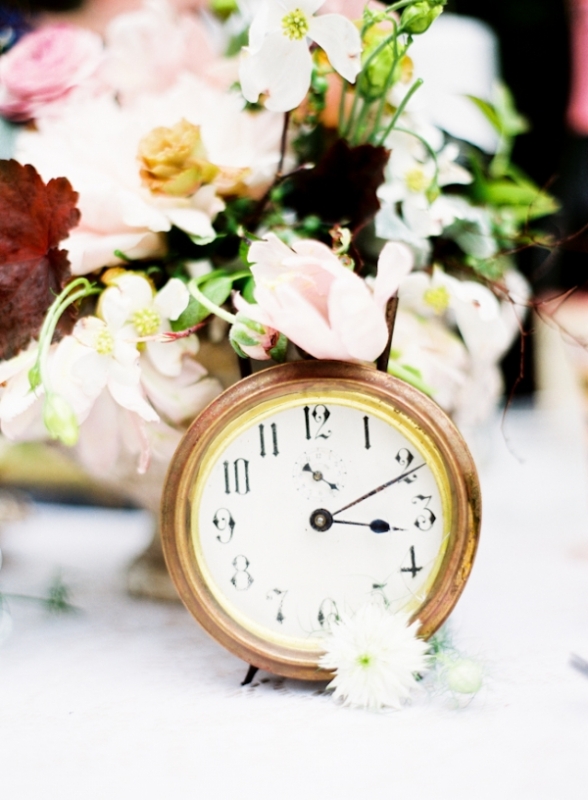 A pastel bloom wedding centerpiece with a clock is a pretty idea for a celestial, NYE or vintage wedding