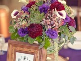 a colorful wedding centerpiece of bright blooms and a clock in a frame for a whimsy vintage wedding reception table
