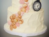 a textural white buttercream wedding cake decorated with pink and gold detailing and an edible clock for fun