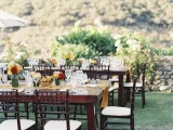 a chic wedding reception with bright table runners, bold blooms and greenery, white chairs