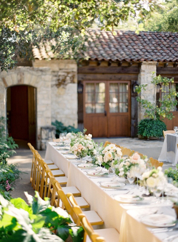 A neutral vineyard wedding reception with neutral linens, neutral and pink blooms and greenery is a chic and beautiful space