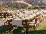 a neutral wedding reception with white linens, greenery and neutral blooms and a cool mountain view