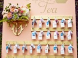 a blush wall with wooden holders, lush florals and vintage teacups with tags and escort cards