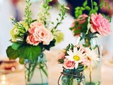 pretty summer wedding centerpieces of blue jars, with pink and neutral blooms and greenery look delicate and romantic