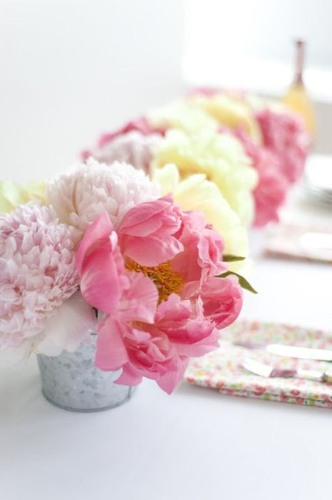 a vivacious summer wedding centerpiece of yellow, blush and coral peonies is lovely and chic