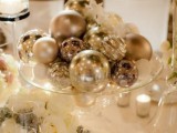 a pretty and easy winter wedding centerpiece of a sheer glass bowl and lots of shiny ornaments in it