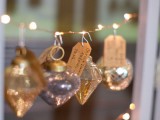 a wedding seating chart done with pretty Christmas ornaments and escort cards is a very creative and festive idea