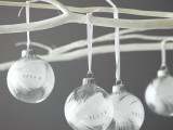 sheer ornaments filled with white feathers and with marks hanging on your Christmas tree will give the wedding a holiday feel