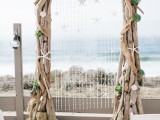 a driftwood wedding arch with starfish, shells, succulents and burlap for a beach or coastal wedding