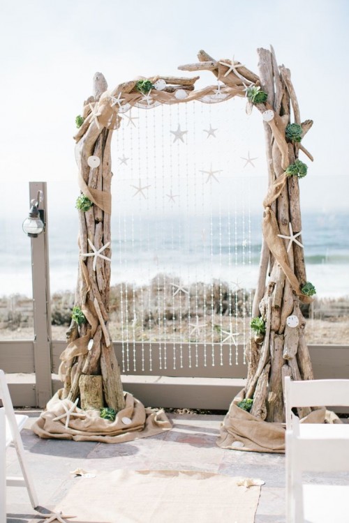 a driftwood wedding arch with starfish, shells, succulents and burlap for a beach or coastal wedding
