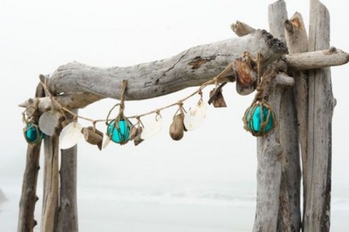 a driftwood wedding arch with seashells, driftwood and buoys is great to install it right on the beach