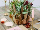 a driftwood wedding arch with burgundy blooms and greenery is very beachy or coastal-like