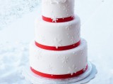 a white winter wedding cake decorated with red ribbon, with snowflakes and white roses on top is a fantastic idea for a winter wedding