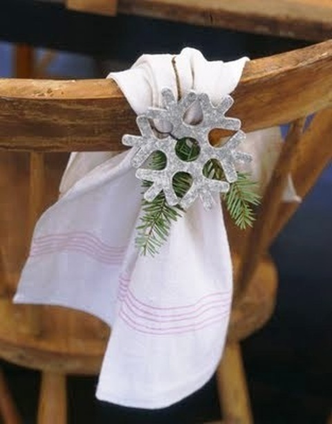 a towel accented with evergreens and silver snowflakes is a creative idea to accent winter wedding chair