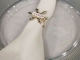 a white napkin with a gold snowflake and a name on top is a lovely idea for a winter wedding, such napkin rings will help you embrace the season