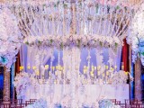 a fantastic lit up and flower-filled wedding ceremony space wiht lights, candles and flower chandeliers is amazing