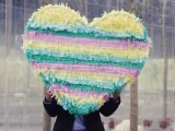 a colorful striped heart-shaped pinata wedding guest book is a very bright and fun idea for a colorful wedding