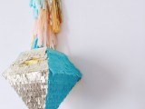 a beautiful and bold turquoise and silver fringe diamond-shaped pinata wedding guest book with colorful tassels is a veyr pretty and cool idea