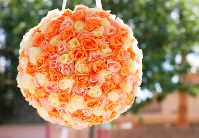 a bright orange, rust and white rose ball-shaped pinata wedding guest book is a colorful and fun idea for a modern wedding