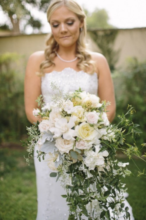 a chic and lovely cascading wedding bouquet of white roses and cascading greenery is a dreamy solution for spring or summer