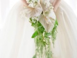 a stylish cascading wedding bouquet of white blooms and some greenery going down is a lovely and cool solution to rock
