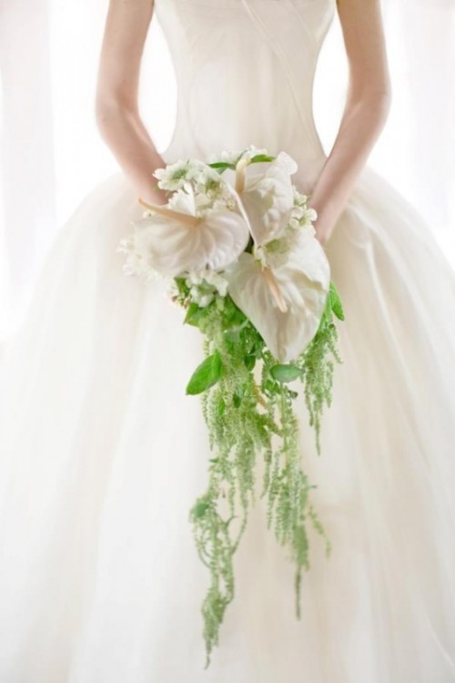 a stylish cascading wedding bouquet of white blooms and some greenery going down is a lovely and cool solution to rock