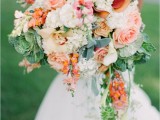 a beautiful super lush cascading wedding bouquet with blush roses, white hydrangeas, cabbage and cascading greenery for a spring or summer rustic wedding