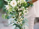 a chic and lush cascading wedding bouquet with neutral blooms, greenery and micro blooms as fillers is a very cool solution for a spring or summer bride