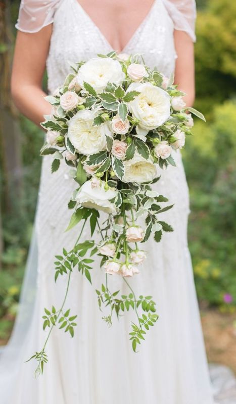 a charming cascading white wedding bouquet white peony roses and blush garden roses and greenery plus cascading parts is a lovely idea for a spring or summer bride