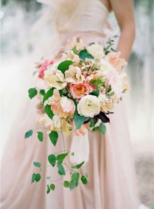 a lush pastel wedding bouquet with neutral and pastel blooms plus cascading greenery is a stylish idea for a spring or summer wedding