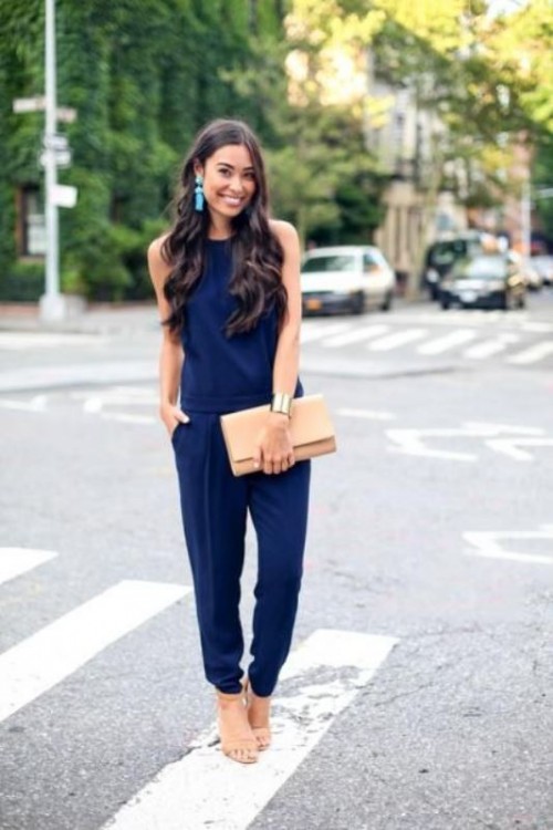 a navy jumpsuit, nude shoes and a neutral clutch, statement colorful earrings