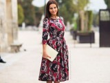 a moody floral midi dress with long sleeves, a neutral clutch and blush heels