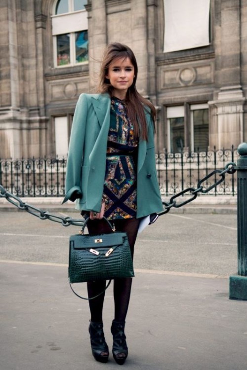 a colorful fitting mini dress, a green blazer, an emerald bag and black shoes with embellishments