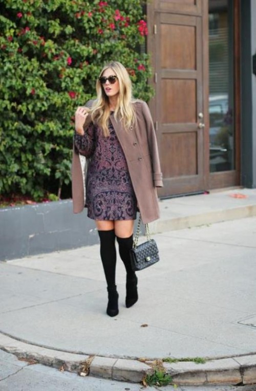 a printed purple over the knee dress, a brown coat, a grey bag and black boots