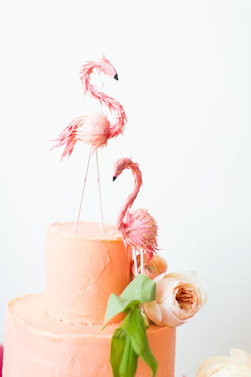 a pink wedding cake topped with pink flamingos and blush peonies is a very cool and bold solution you may rock