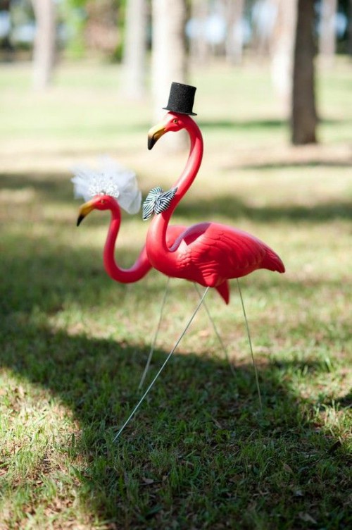 pink flamingos dressed up as the marrying couple is a fun and cool idea for your wedding