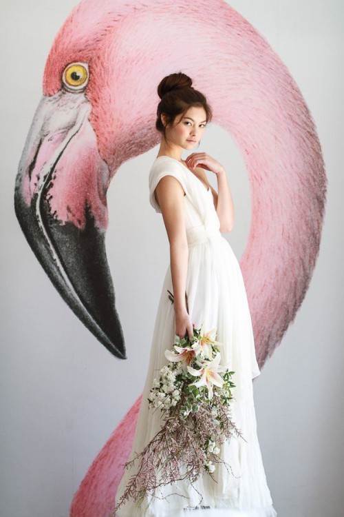 a bridal portrait taken in front of the wall with a pink flamingo is a creative idea of a backdrop that looks tropical-like