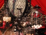 an elegant dark-colored Halloween sweets table with refined jars and black bows on top is a gorgeous idea