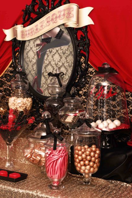 an elegant dark-colored Halloween sweets table with refined jars and black bows on top is a gorgeous idea