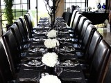 a total black Halloween tablescape refreshed with white blooms and striped napkins is a lovely idea for a Halloween bridal shower