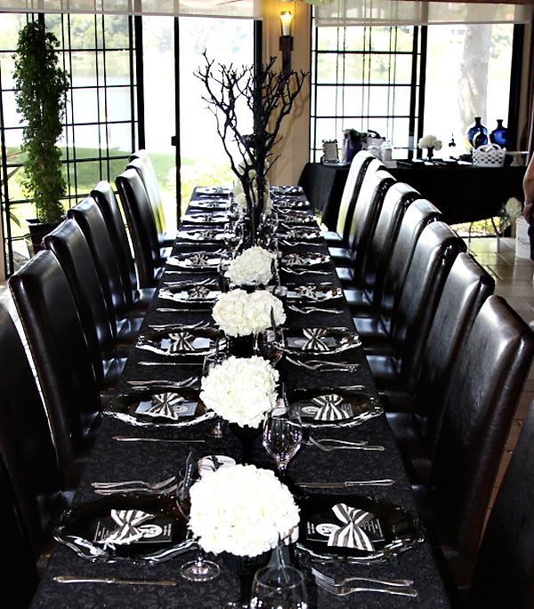 A total black Halloween tablescape refreshed with white blooms and striped napkins is a lovely idea for a Halloween bridal shower
