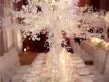 a frozen winter wedding table with frozen branches and crystals, baby’s breath and floating candles