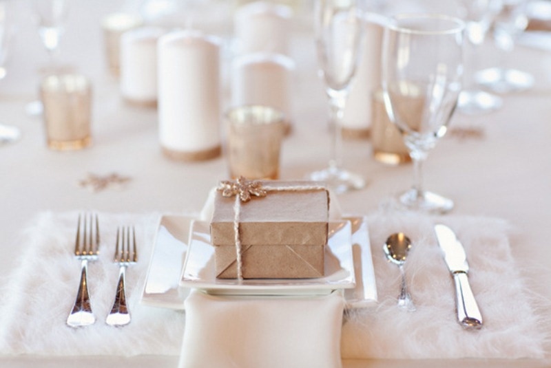a neutral winter wedding table with candles, metallic candleholders, silver cutlery and fluffy placemats