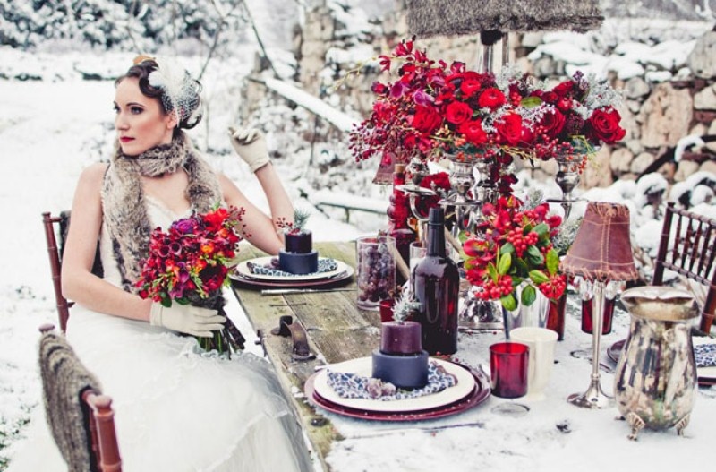 a bright winter wedding table done in purple, taupe, red and with metallic candleholders, vases and lamps