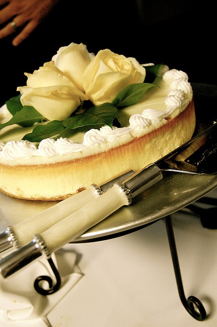 a wedding cheesecake topped with whipped cream and white roses looks refined and elegant