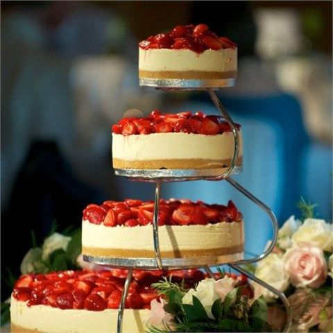 an assortment of classic cheesecakes topped with fresh strawberries on stands is a trendy idea