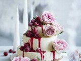 a three-tiered white chocolate cheesecake with fresh raspberries and strawberries, pink roses is a refined idea
